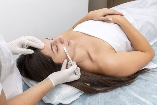professional performing dermaplaning treatment on client’s face