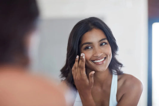 woman applying sunscreen as part of her daily regimen